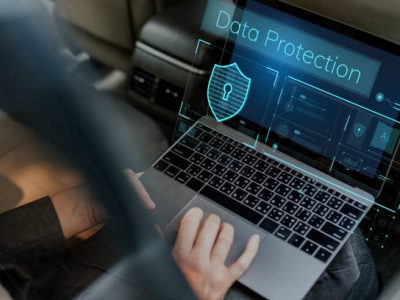 Image: A laptop with a lock symbol on the screen, surrounded by a shield. Protect your laptop from hackers with strong passwords and updated security software.