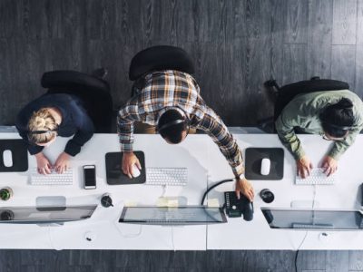 Five people collaborating at a desk in a professional office setting.